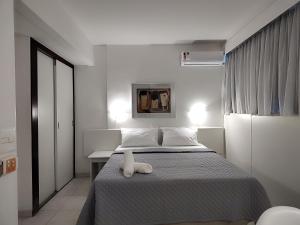 贝洛奥里藏特Hotel Oscar Gold Savassi的卧室里设有一张床,上面有一只动物