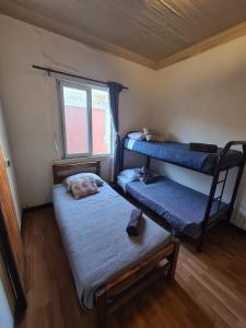 维纳德马VOY Hostales - Oriente的小房间设有两张双层床和椅子