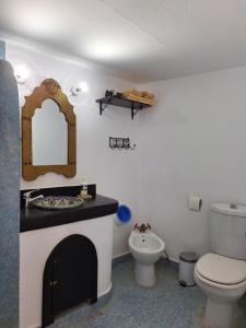 舍夫沙万达累斯萨拉姆加布里埃尔旅馆的一间带卫生间、水槽和镜子的浴室