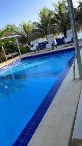 CalliaquaPoint Bay Resort的一个带椅子和棕榈树的大型蓝色游泳池
