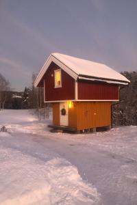 LundeUnik overnatting i Stabbur/Minihus的雪上积雪的小房子