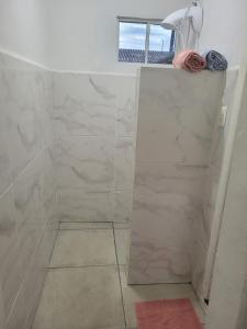 拉热斯Suíte 2 com sala的浴室设有白色大理石瓷砖和淋浴。