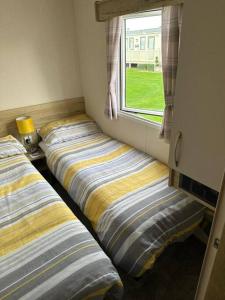 法利Primrose valley - Primrose Field 46 holiday home的两张床位于带窗户的房间内