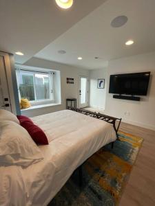 丹佛Private, cozy, suite by Mile High Stadium and Downtown Denver!的一间卧室设有一张大床和一台平面电视。