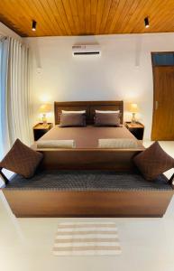 康提Rani Suite and Cabin的一间卧室配有一张带2个床头柜的大床