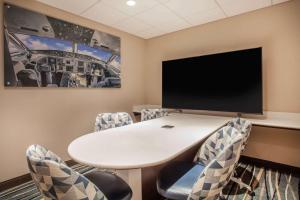 奥兰多奥兰多国际机场温盖特温德姆酒店的一间会议室,配有桌椅和一台平面电视