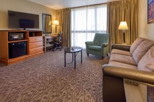亚特兰大亚特兰大机场德鲁酒店的一间客厅,客厅配有沙发和一张书桌,位于酒店的房间