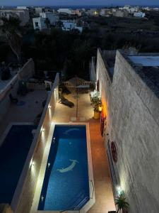 纳杜尔Tal-Bir Farmhouse的夜间在房子的一侧的游泳池