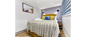 罗姆福特Newly Renovated 1BD Flat Perfect for Travellers的一间卧室配有一张黄色床头板的床