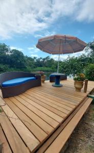 莫雷蒂斯Pousada Siroba Beira Rio的木制甲板上配有长凳和遮阳伞