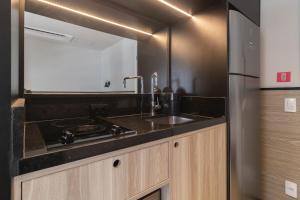 圣保罗Housi Paulista的厨房配有水槽和不锈钢冰箱
