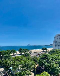 里约热内卢Loft Praia de Copacabana的享有树木繁茂的海滩和大海的景致。