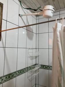 迦太基La Cabaña: Descanso y Naturaleza的浴室设有白色瓷砖墙壁和灯