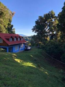 迦太基La Cabaña: Descanso y Naturaleza的绿色田野上一座红色屋顶的房子