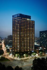 首尔Shilla Stay Mapo Hongdae的一座高大的建筑,旁边有一个标志