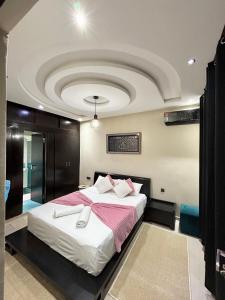 马拉喀什Appartement Duplex élégant et calme Marrakech Menara的一间卧室设有一张带天花板的大床