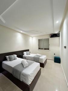 马拉喀什Appartement Duplex élégant et calme Marrakech Menara的一间卧室配有两张床和电视。