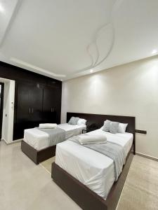 马拉喀什Appartement Duplex élégant et calme Marrakech Menara的一间卧室配有两张带白色床单的床