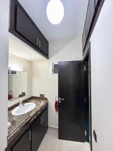 马拉喀什Appartement Duplex élégant et calme Marrakech Menara的一间带水槽和黑色门的浴室