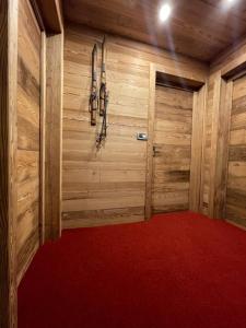萨奥兹-杜尔克斯卡赛瓦肯萨佩隆酒店的一间铺有红地毯的木墙客房