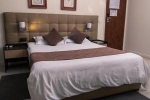 马普托Hotel Monte Carlo的一间卧室配有一张大床和大床头板