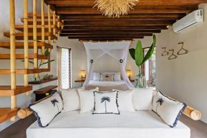 乌鲁瓦图Acacia Bungalows Bingin的卧室配有带枕头的白色床