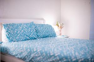 罗金汉姆Rockingham Beach Breeze 2br Retreat的一张带蓝色棉被和枕头的床