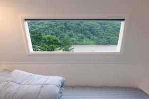 春川Chuncheon Healing Bridge的白色客房内的大窗户,配有床