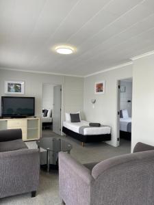 旺阿雷肯辛顿汽车旅馆的酒店客房配有床、沙发和电视。