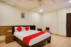 海得拉巴OYO Flagship HOTEL SREE SIMRAN PALACE的一间卧室配有一张带红色枕头的大床