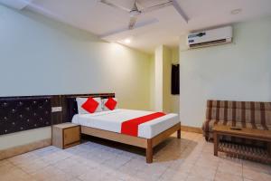 海得拉巴OYO Flagship HOTEL SREE SIMRAN PALACE的一间卧室配有红色枕头的床