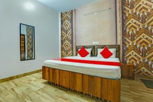 卢迪亚纳OYO HOTEL WINNER INN的一间卧室配有一张带红色枕头的大床