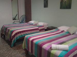 比加瓜Habitacion en Bijagua的客房内的两张床和条纹床单