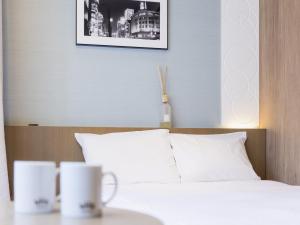 东京格拉斯丽银座酒店的一间卧室配有一张桌子上的两张马克床