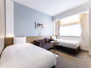 东京格拉斯丽银座酒店的酒店客房,配有两张床和椅子