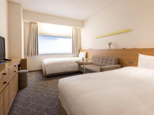 东京格拉斯丽银座酒店的酒店客房设有两张床和电视。