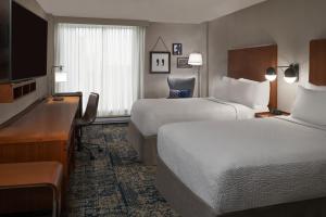 加蒂诺Four Points by Sheraton Hotel & Conference Centre Gatineau-Ottawa的酒店客房配有两张床和一张书桌