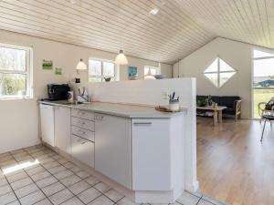 希茨海尔斯8 person holiday home in Hirtshals的一间大厨房,配有白色的橱柜和一张桌子