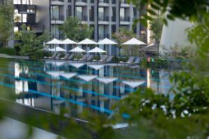 功孟海滩VARANA Hotel Krabi的一座带椅子和遮阳伞的游泳池位于一座建筑旁边