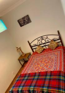 安卡拉Ankara Merkezde Piyanolu Daire的一间卧室配有一张带五颜六色棉被的床