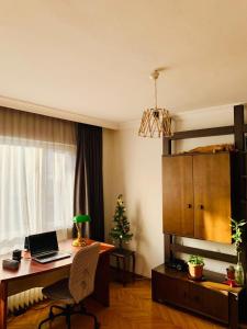 安卡拉Ankara Merkezde Piyanolu Daire的客房设有一张带笔记本电脑和圣诞树的书桌。