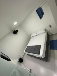 卡鲁阿鲁Quarto privativo com banheiro compartilhado em Pousada recém construída,a 500mts do pátio do forró的一间白色的小客房,天花板上设有一张床