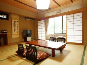 水上町Yumoto Choseikan的客厅配有木桌和椅子