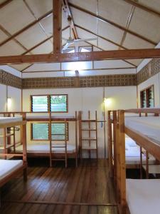 巴迪安Eskapo Verde Resort Moalboal的带三张双层床和两扇窗户的房间