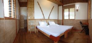巴迪安Eskapo Verde Resort Moalboal的卧室配有一张白色大床