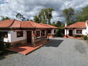 莱瓦镇Cabañas Villa Encanto的前面有砂石车道的房子