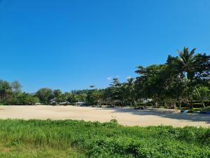 奈扬海滩普吉岛泳池别墅的远处拥有棕榈树的沙滩