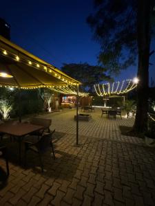 迪马普尔Premier Lodge的庭院在晚上配有桌子和遮阳伞