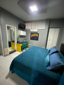 瓜亚基尔SUITES FullHouse的一间带蓝色床的卧室和一间客厅