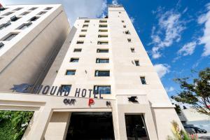 木浦市Hound Hotel Mokpo Peace Plaza的上面标有酒店标志的高大的白色建筑
